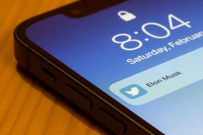 Notification showing a new tweet from Elon Musk is seen on the lock screen of an iPhone.