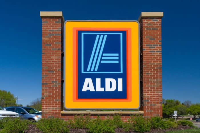Close up of Aldi signage against a blue sky.