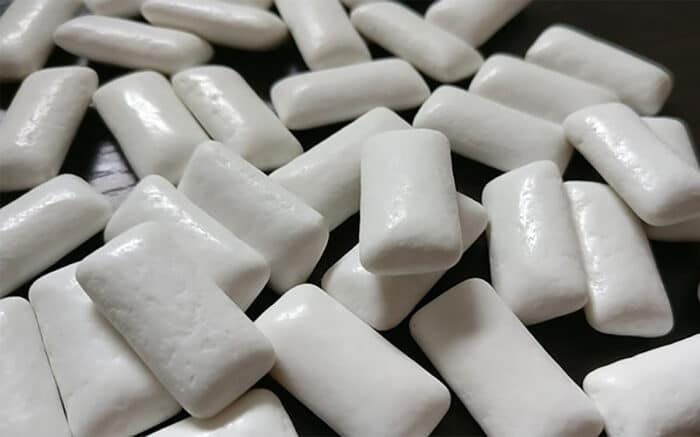 Close up of gum pieces on top of a dark table.