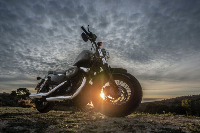 Harley Davidson motorcycle against a dramatic cloudy sunset sky.