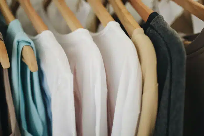 Close up of womens shirts hanging on a clothing rack.