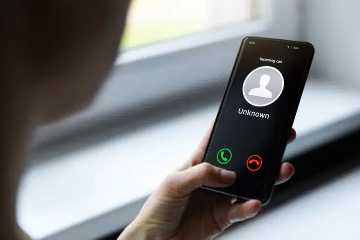 Close up of a womans hands holding a smartphone that is receiving a robocall - medicredit lawsuit