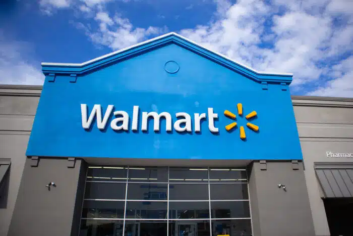 Walmart exterior entrance against a bright blue sky.