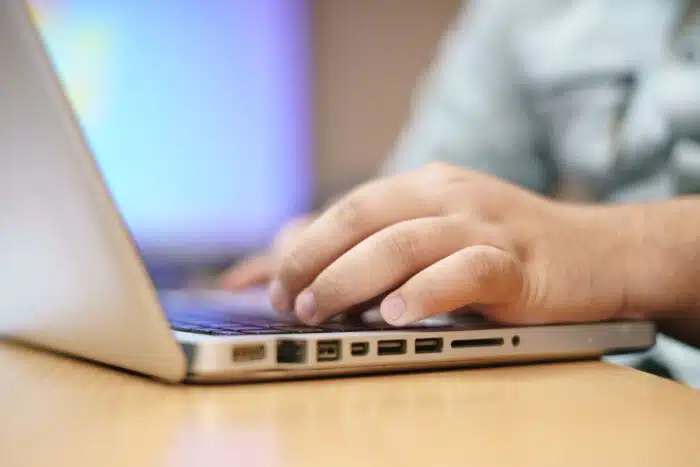 Close up of a hand typing on a computer.