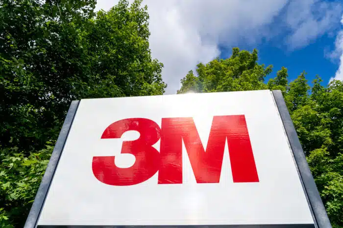Close up of 3M sign with tree and blue sky in background - 3m wolverine settlement