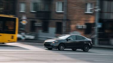 Black Dodge Dart car moving on the street.