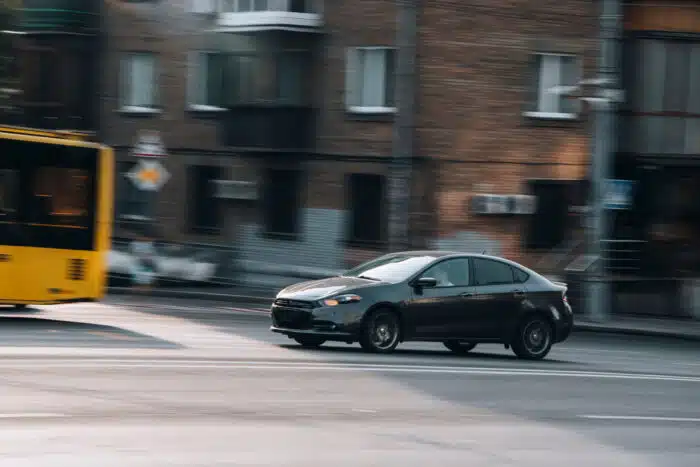 Black Dodge Dart car moving on the street.