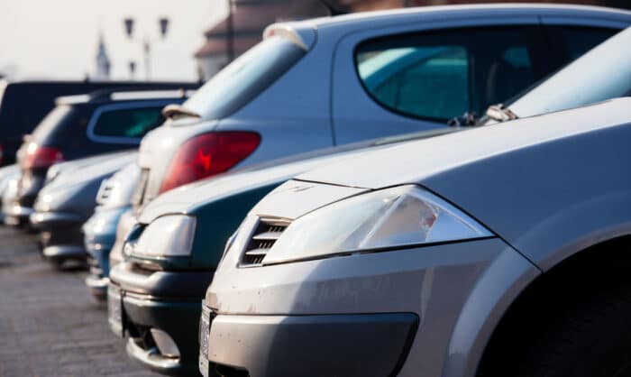 Close up of a variety of different vehicles in a parking lot.