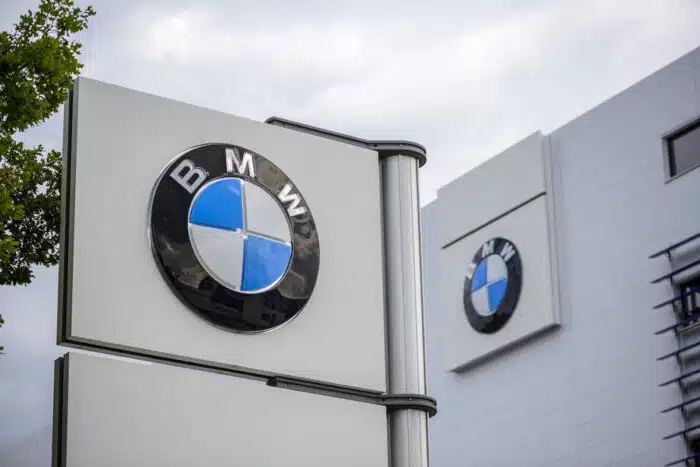 Close up of BMW signage against a blue sky.