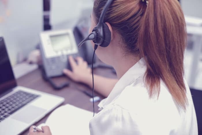 Back view of a female telemarketing making a call - debt collection settlement