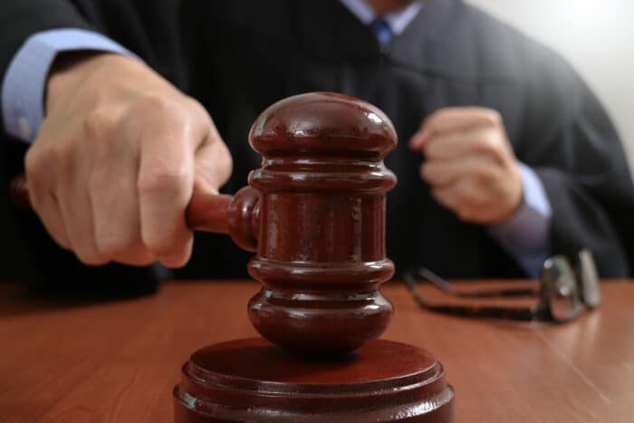 Male judge in a courtroom striking the gavel.