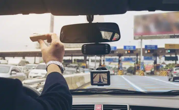 A person in a car reaches an e-toll stop on a highway - avis toll