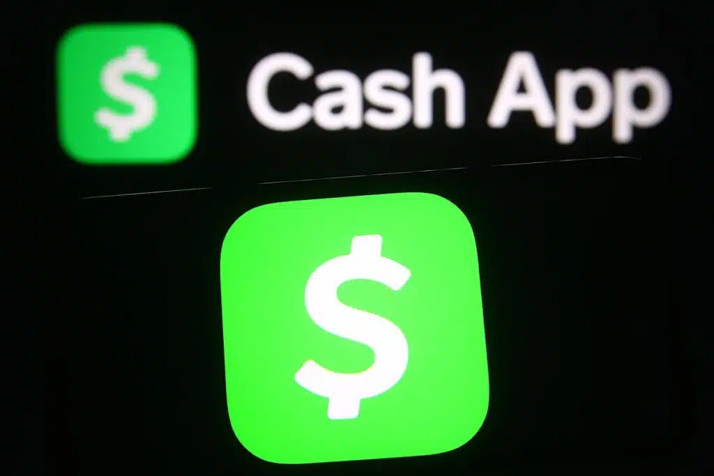 Cash App logo of the mobile payment service is seen on a mobile phone and a computer screen.