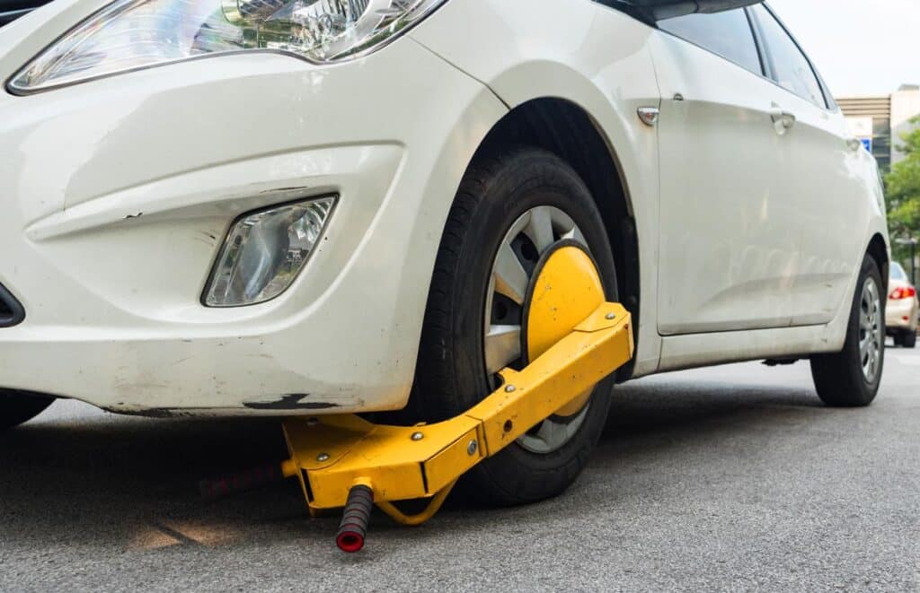 Close up of a wheel lock on a vehicle wheel, representing the Secure Parking Enforcement booting class action settlement.