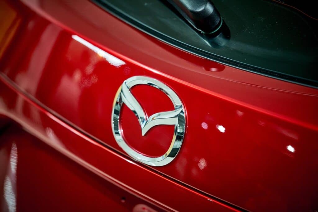 Taillight of Mazda 3 modern sporty hatchback with reflection on rear red paint after paint polishing and coating.