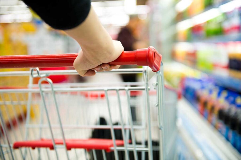 Close up of a woman's hand pushing a shopping.