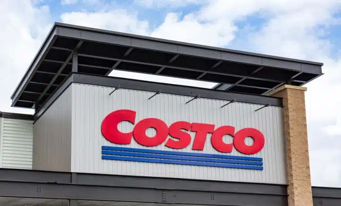 Close up of Costco signage against a blue sky.