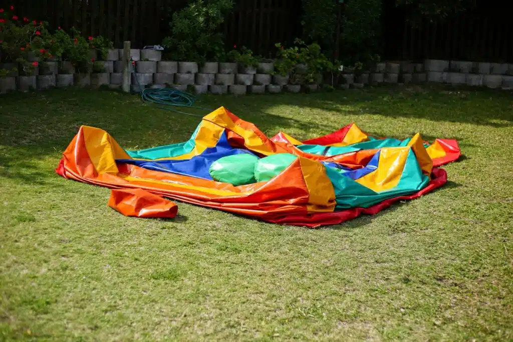 A colorful deflated jumping castle on a green lawn.