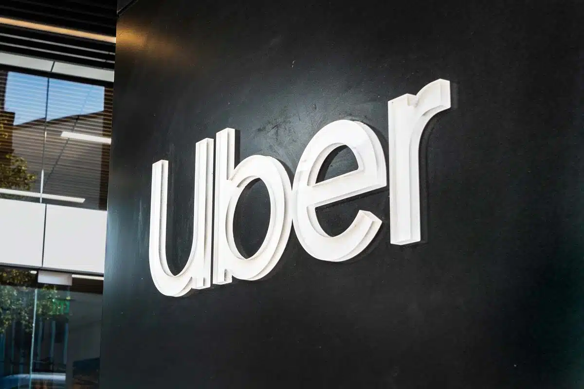 Close up of the Uber logo on a black wall, representing the Uber ADA discrimination class action settlement and class action lawsuits.