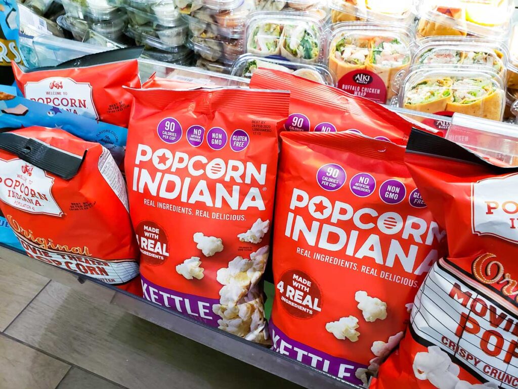 Several packages of Popcorn Indiana on display at a convenience store.