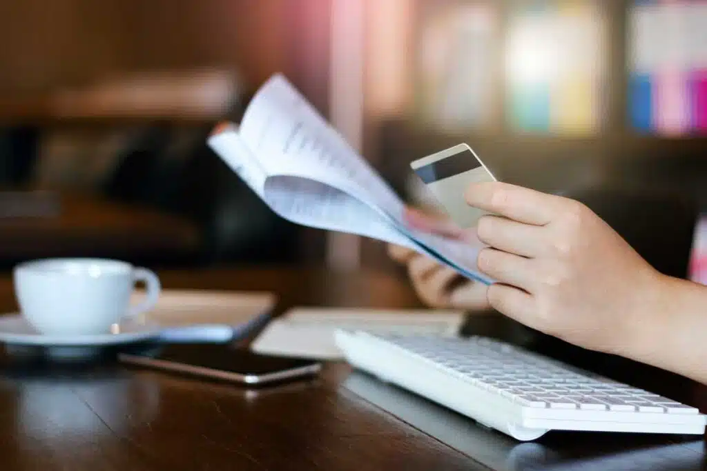 Close up of a womans hands checking a credit card statement, representing the IH Mississippi Valley Credit Card fee class action settlement.