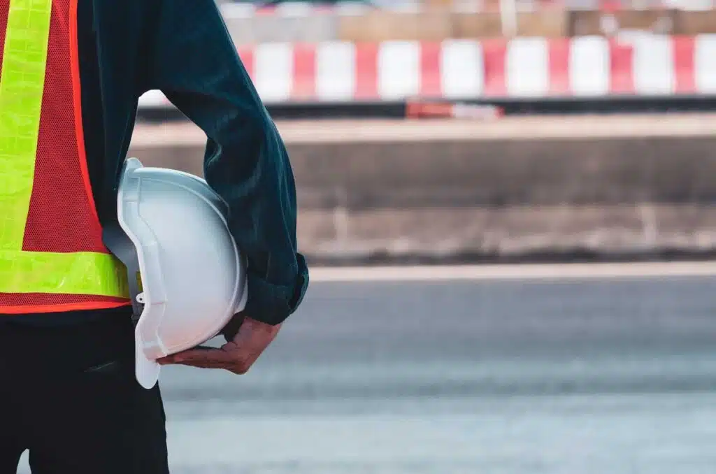 Close up of an inspector holding a white hard hat, representing the Storm Water Inspection & Maintenance Services, or SWIMS, class action settlement.