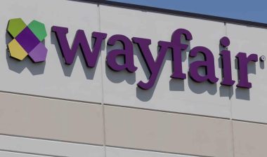 Close up of Wayfair signage against a blue sky.