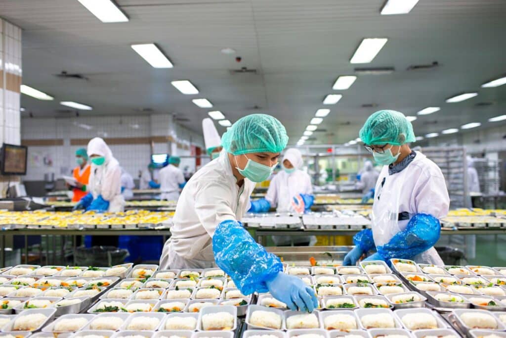 Catering workers preparing packaged meals, representing the Gate Gourmet off-the-clock work lawsuit settlement.
