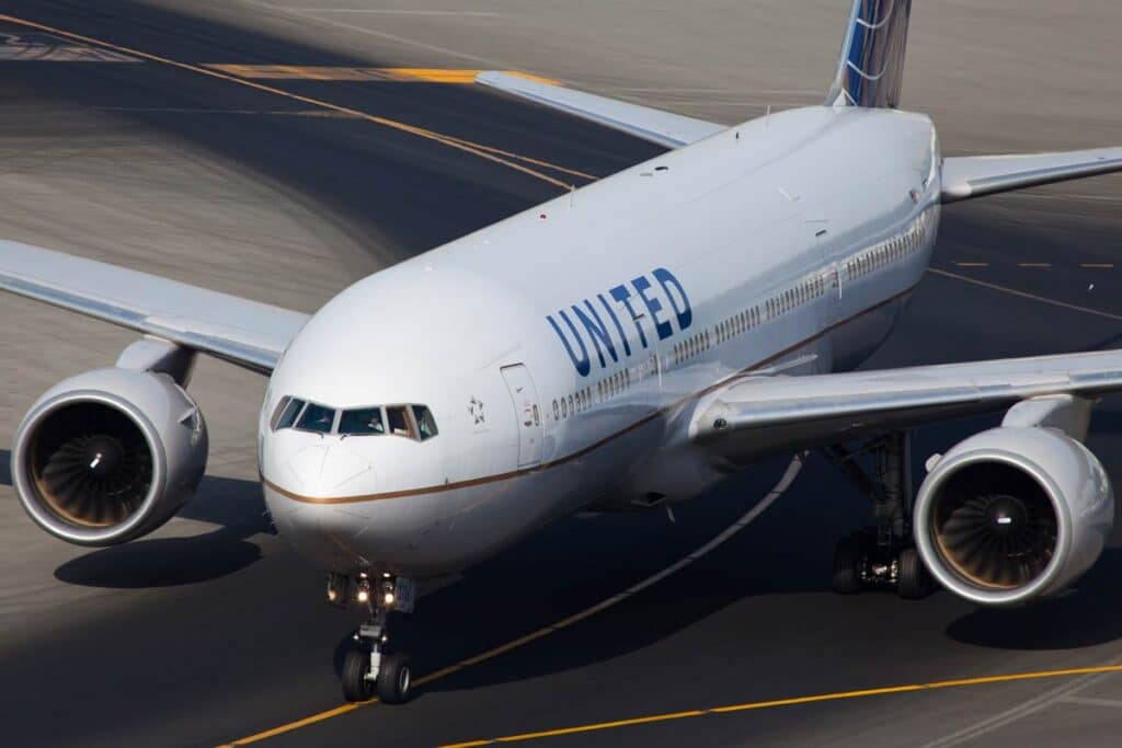 An American airline, United, B777 plane is taxiing to a gate.