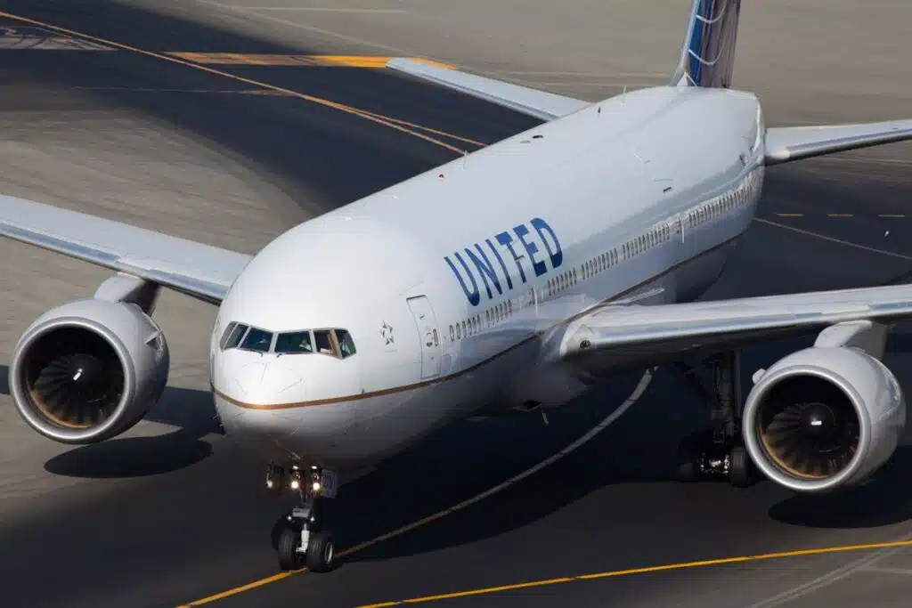 An American airline, United, B777 plane is taxiing to a gate.
