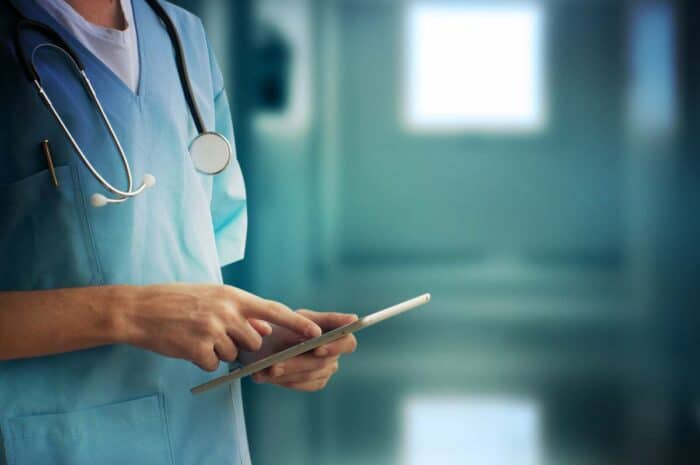 Close up of a healthcare workers hand using an electronic tablet. Healthcare data breach concept - Advocate Aurora class action