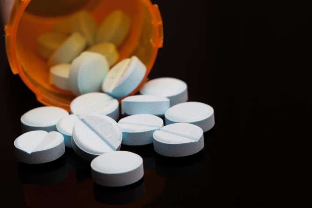 Close up of pills spilling out of a prescription bottle.