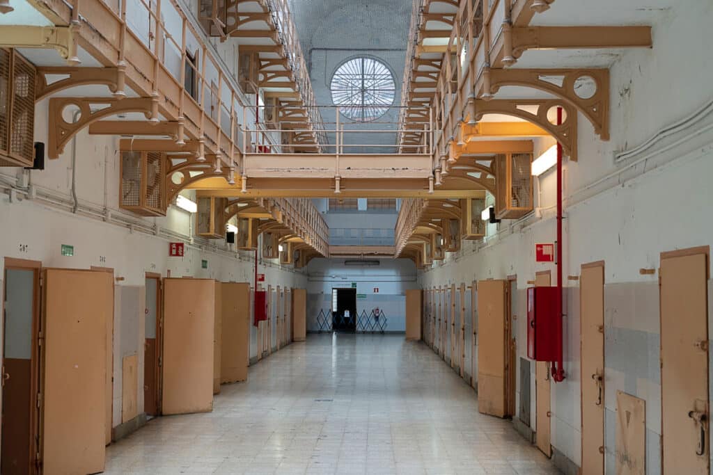 Prison interior. Two-story prison corridor with prison cell doors.