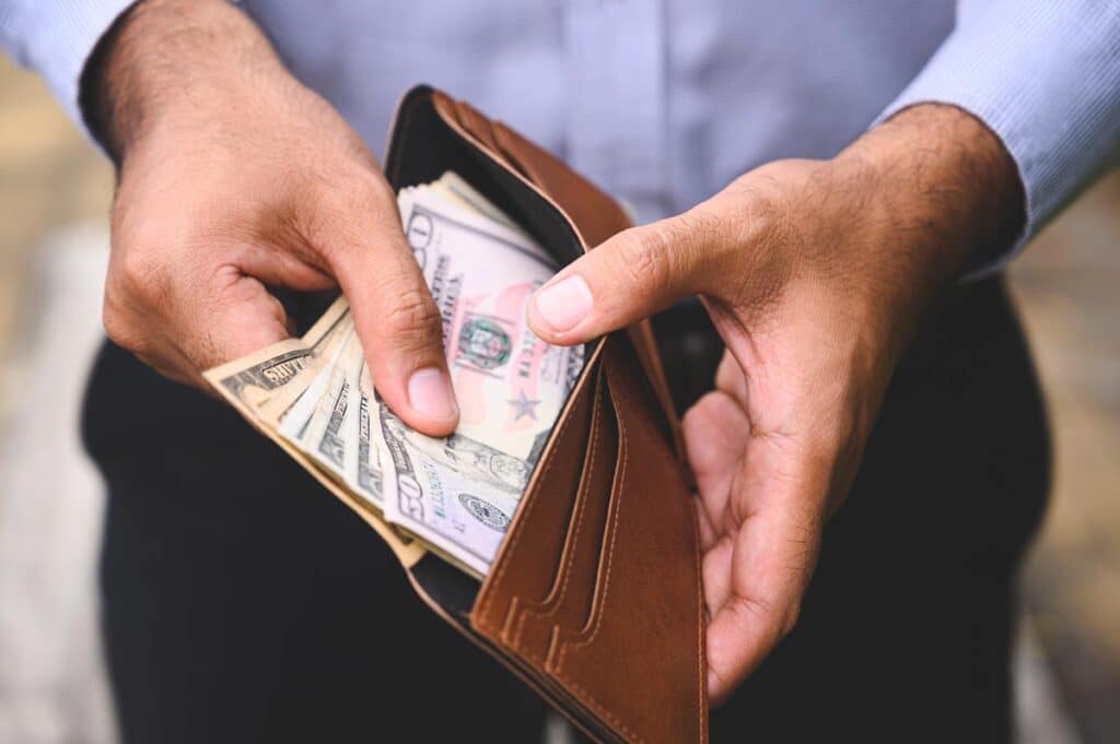 Close up of a business man pulling cash out of his wallet.
