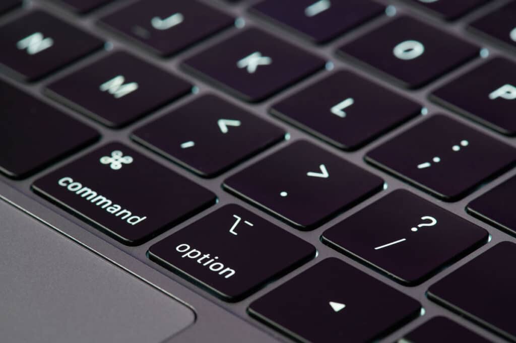 Close up view on gray color macbook pro keyboard with new butterfly technology, representing the Apple MacBook butterfly keyboard class action lawsuit settlement.