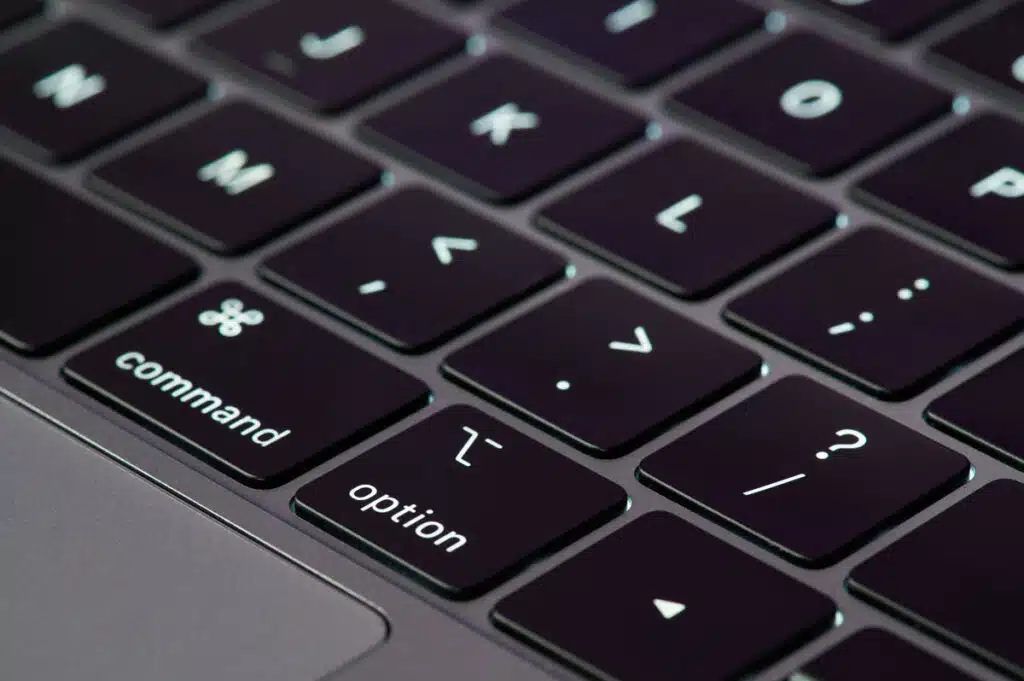 Close up view on gray color macbook pro keyboard with new butterfly technology, representing the Apple MacBook butterfly keyboard class action lawsuit settlement.