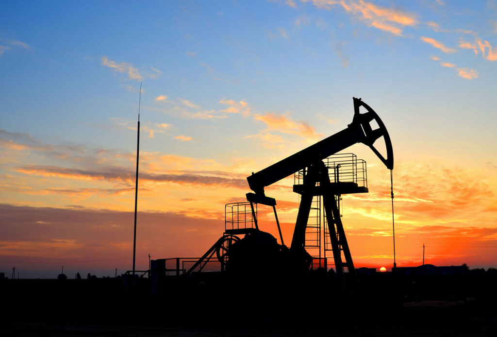 Silhouette of an oil rig against a sunset sky, representing the Kaiser-Francis Oil Co. gas royalties settlement.