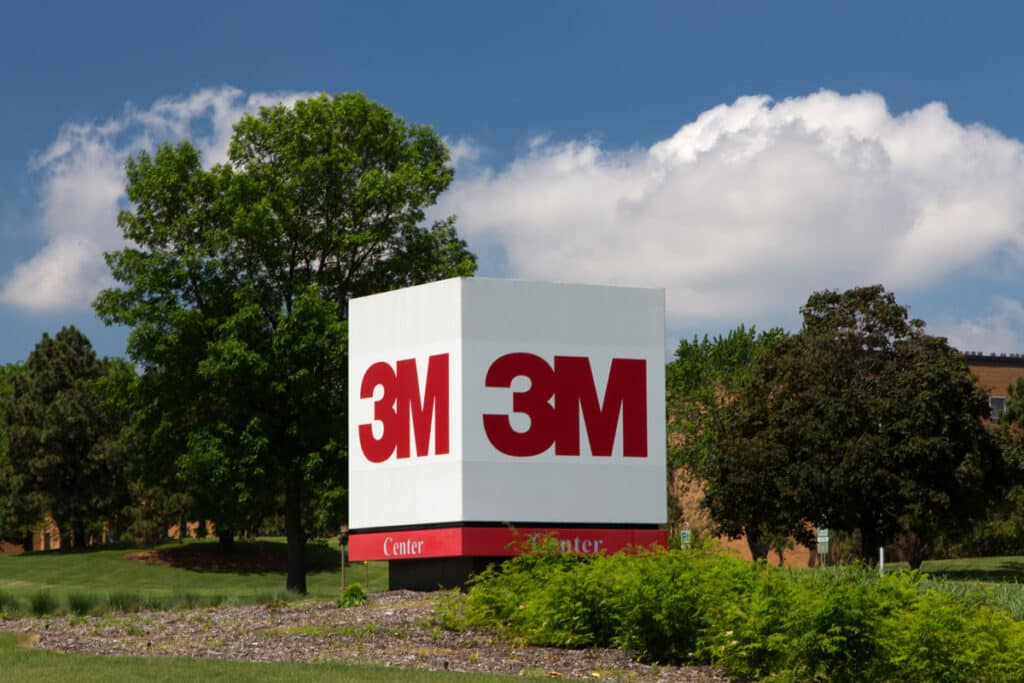 3M logo against a blue sky and foliage.