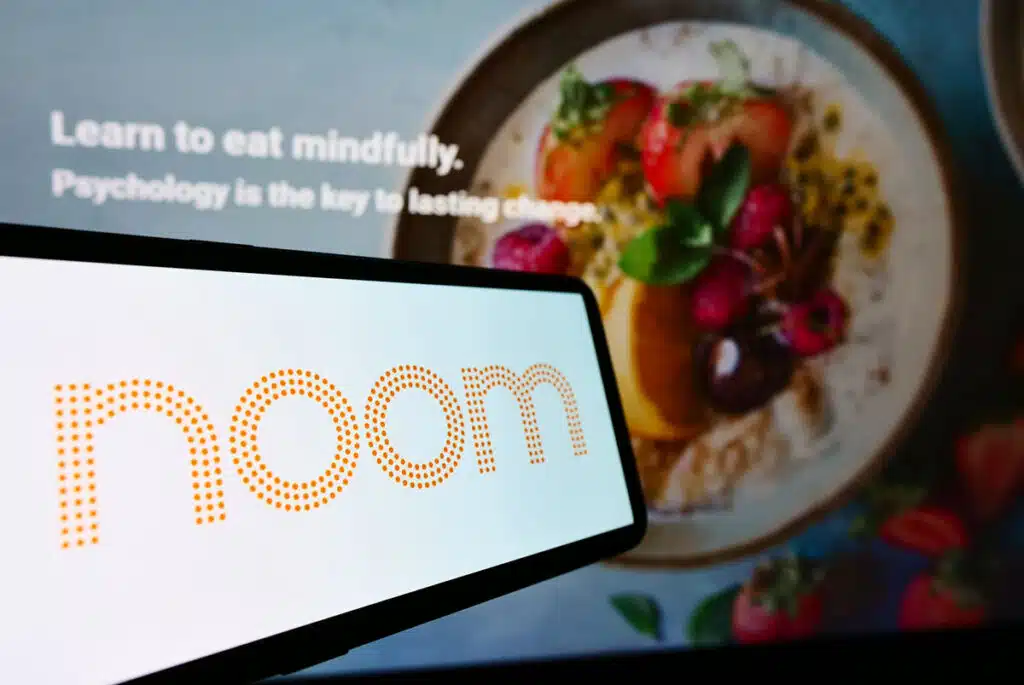 Smartphone with logo of US weight-loss platform company Noom Inc on screen.