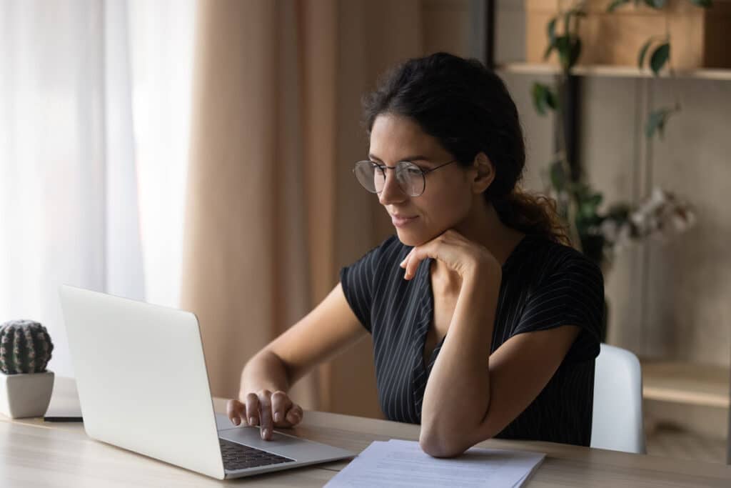 Close up of a woman using a laptop computer, representing the Ibex data breach class action lawsuit settlement.