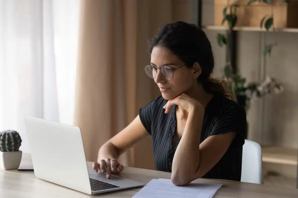 Close up of a woman using a laptop computer, representing the Ibex data breach class action lawsuit settlement.