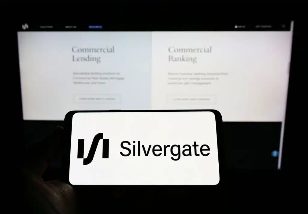 Person holding mobile phone with logo of American financial services company Silvergate Bank on screen.