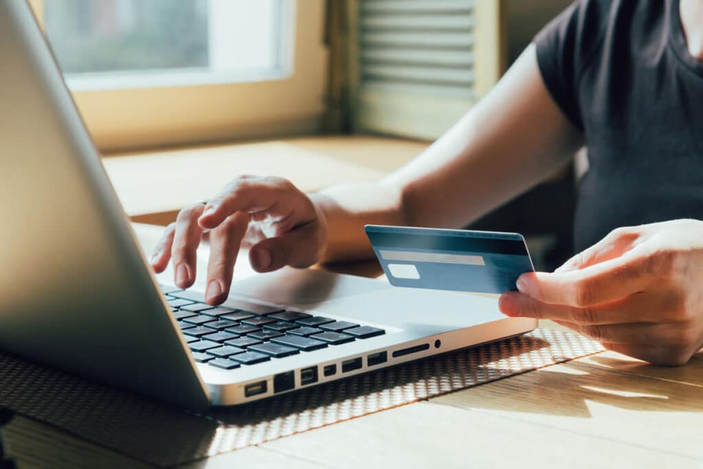 girl makes a purchase on the Internet on the computer with credit card, representing the Bradford Exchange auto-renewal class action lawsuit settlement.