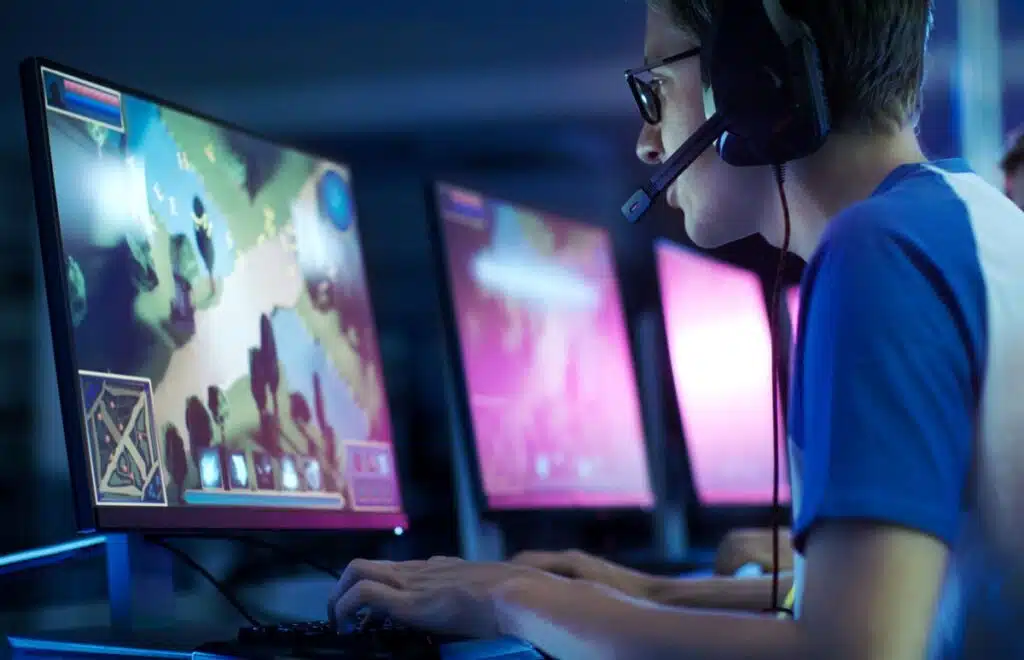 Close up of a male gamer playing a game on a computer screen.