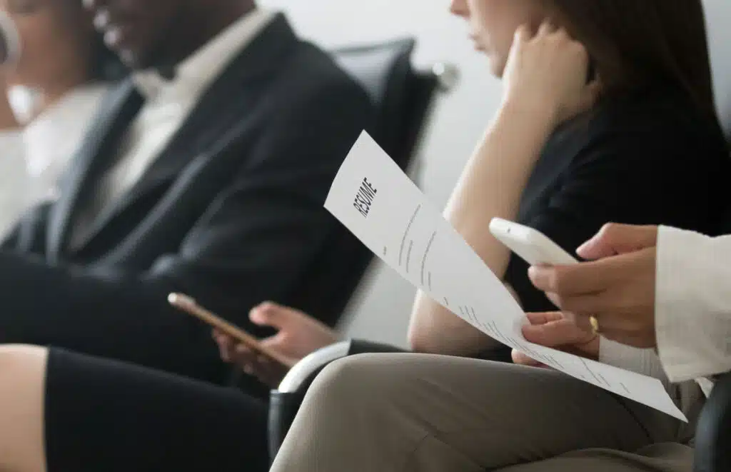 Close up of prospective job candidates waiting in a room, representing the MVP racial discrimination settlement.