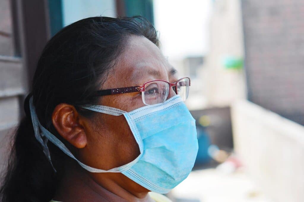 Close up of a native american woman wearing a mask.