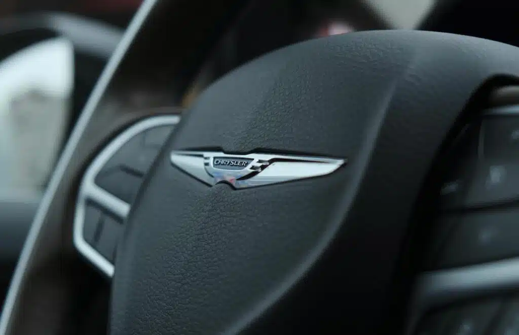 Close up of Chrysler emblem on a steering wheel, representing the Chrysler Pacifica recall.