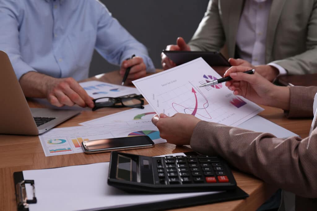 Business people working with documents at table in office, closeup.