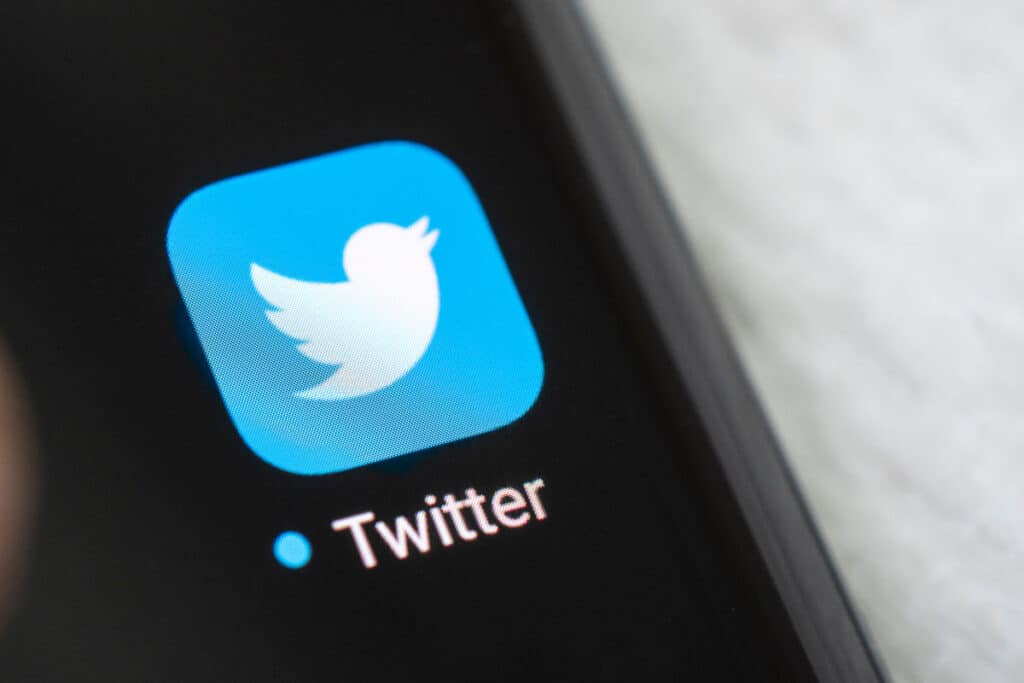 Close up of Twitter app icon displayed on smart phone screen.