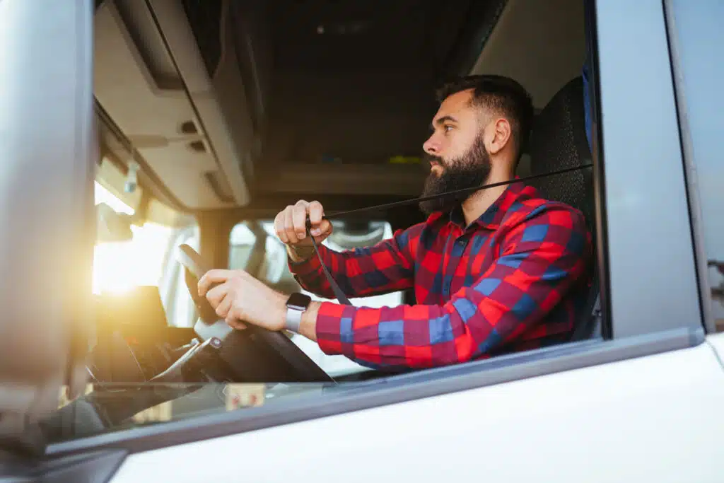 Truck driver buckling his seatbelt, representing the T-Force class action lawsuit settlement.